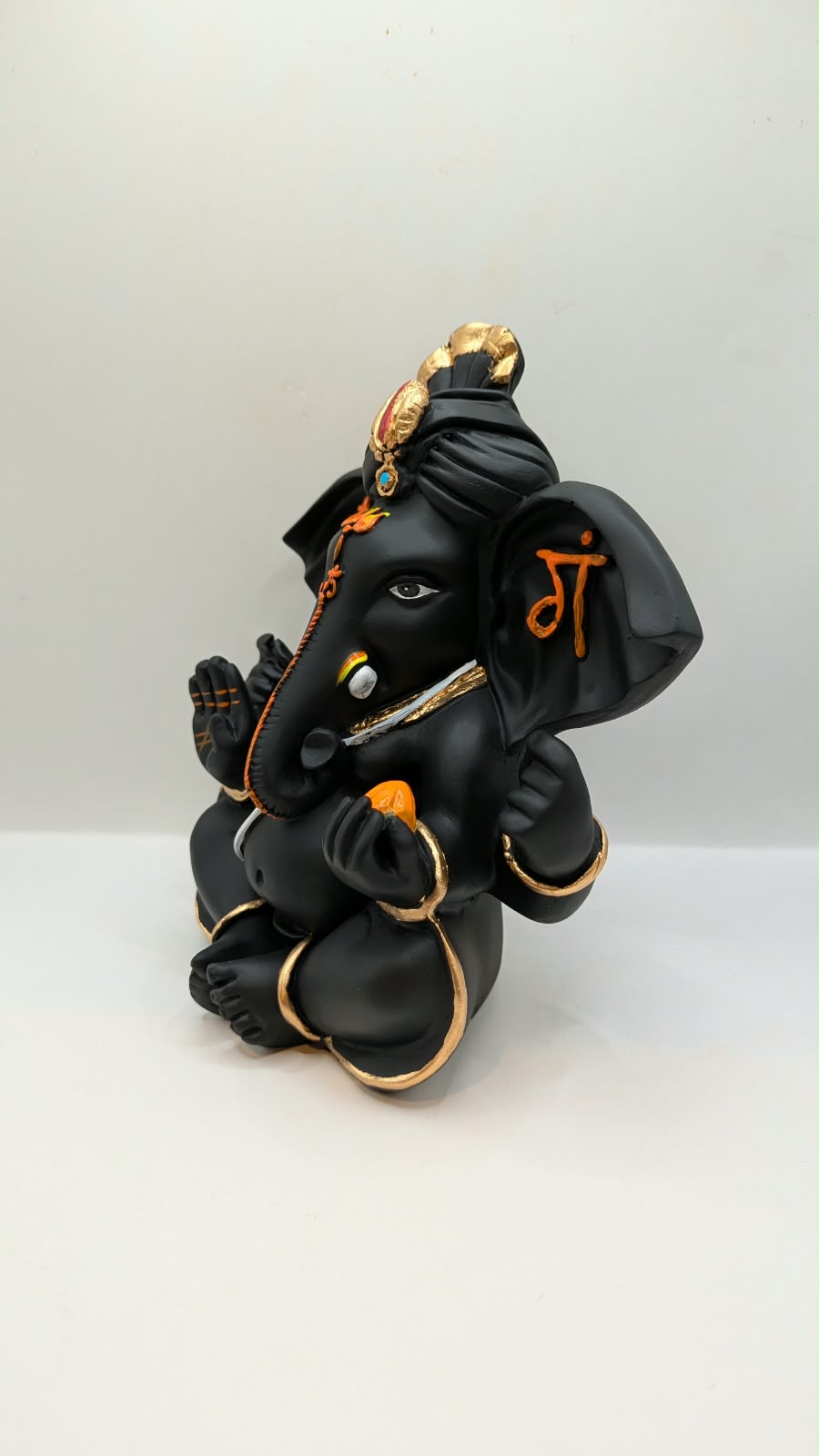 Black Ganesh statue with Shri on ears, other side view