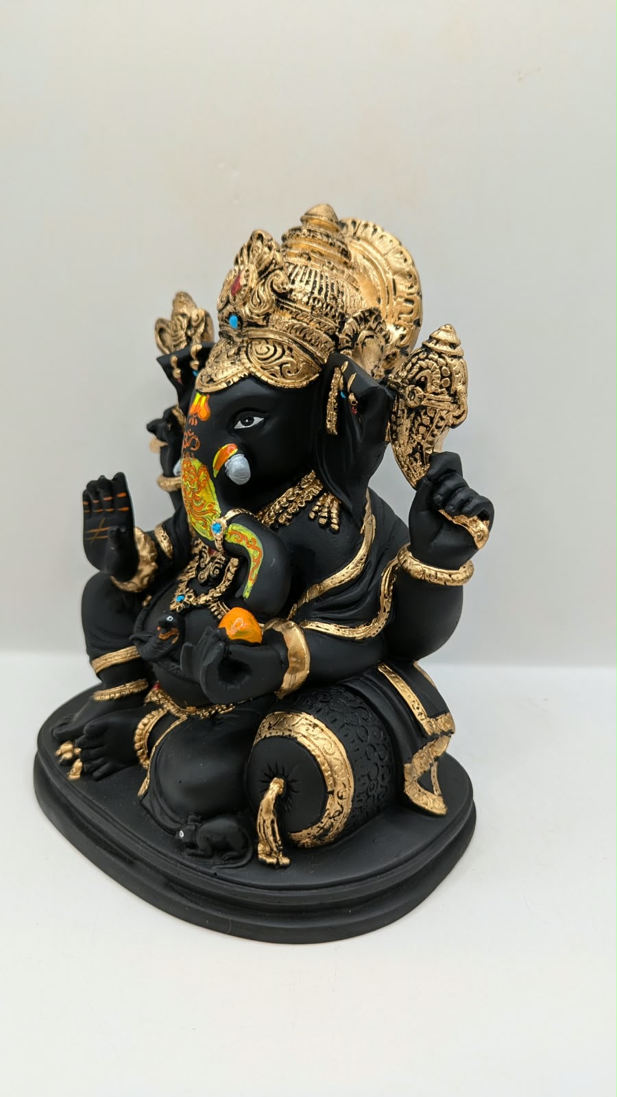 Black and gold Ganesh statue with crown, other side view