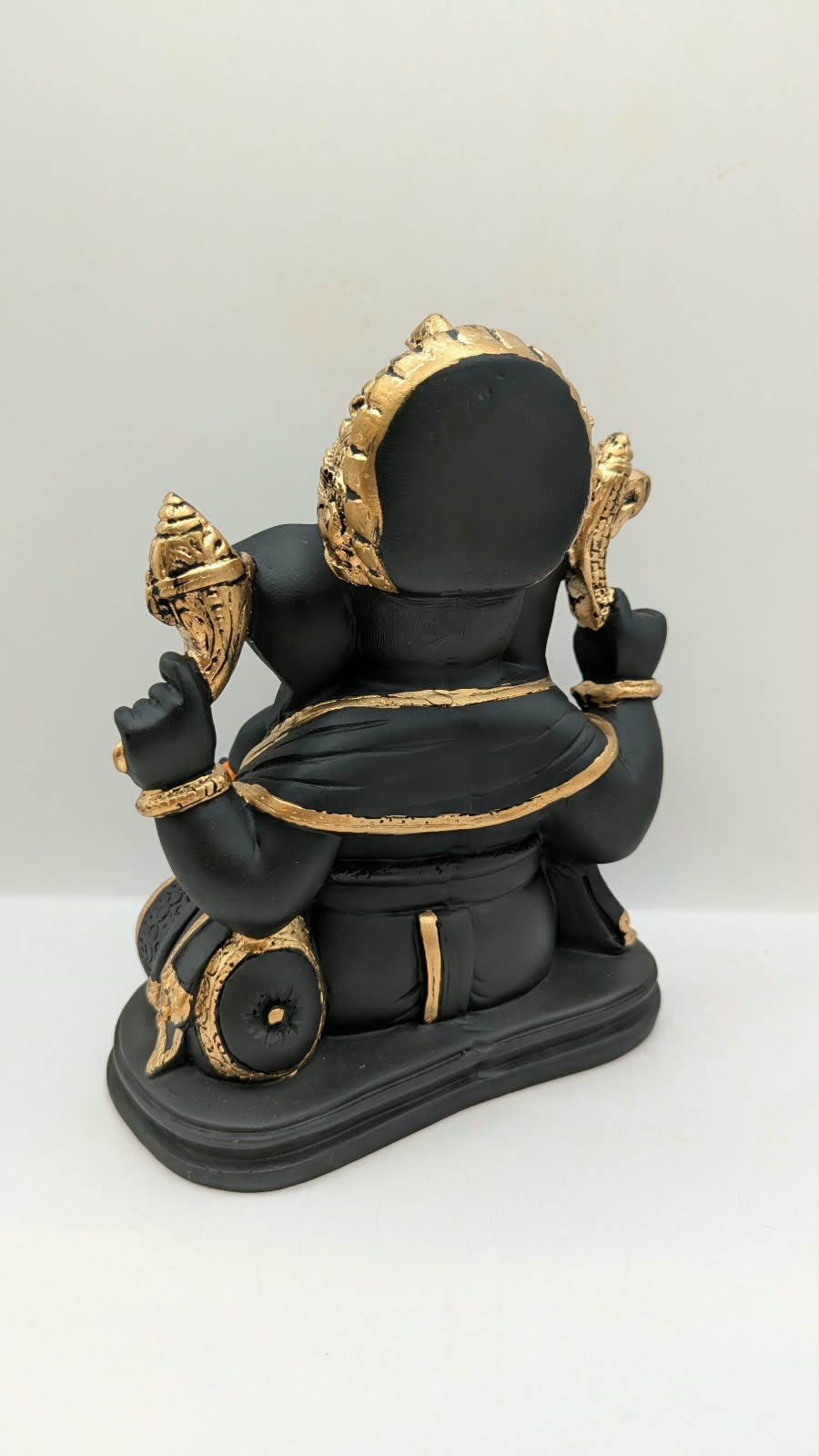 Black and gold Ganesh statue with crown, back view