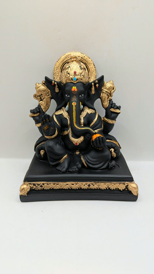 Black and gold Ganesh statue on throne base, front view