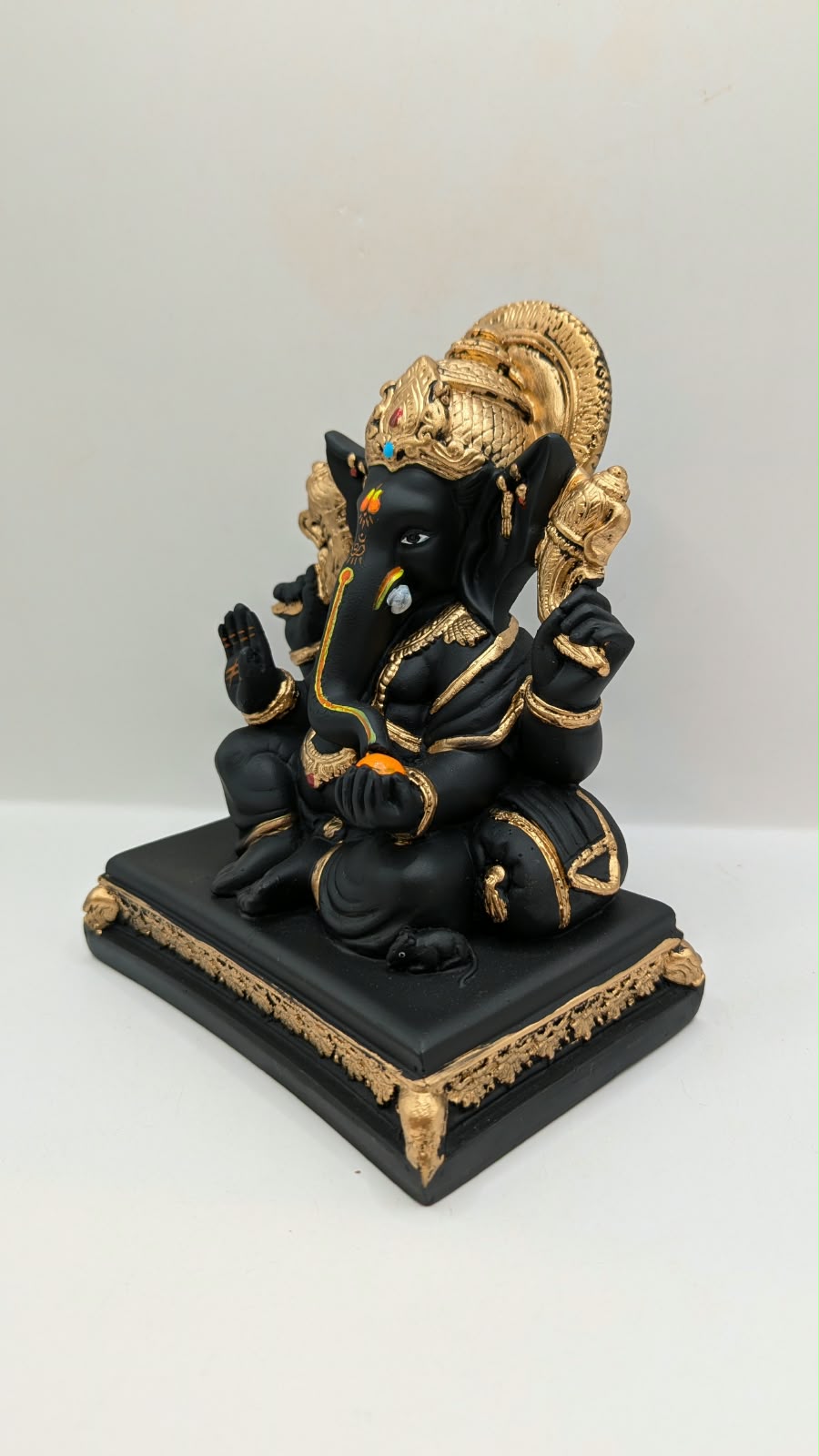 Black and gold Ganesh statue on throne base, other side view