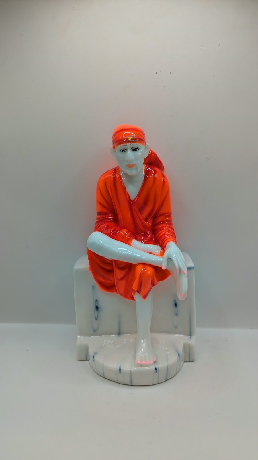 Sai Baba statue on white seat, front view