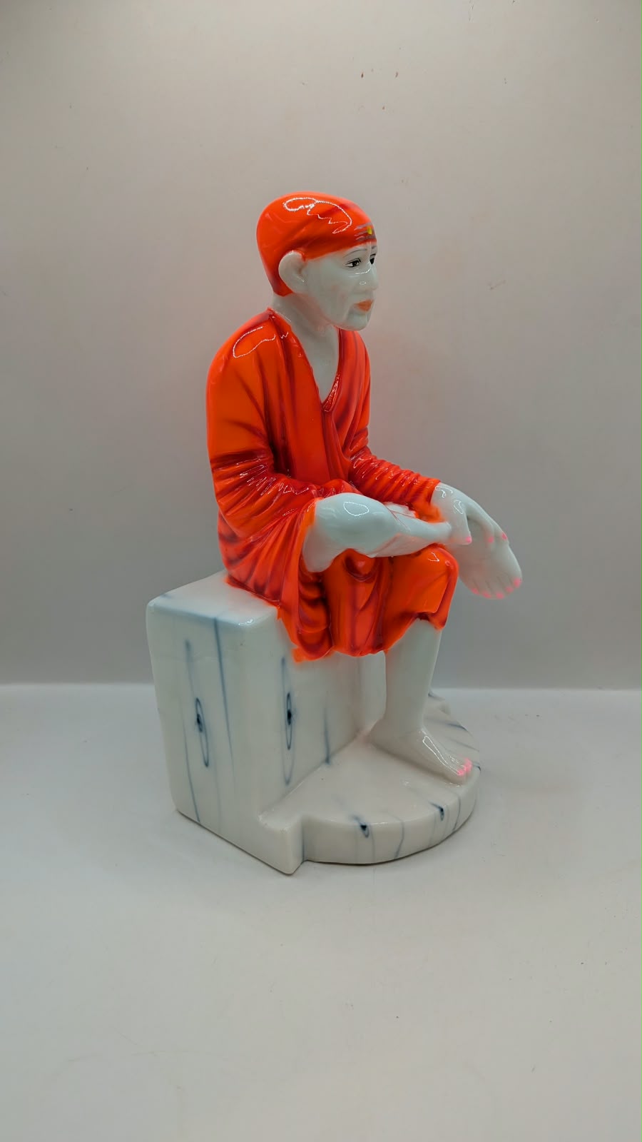 Sai Baba statue on white seat, side view
