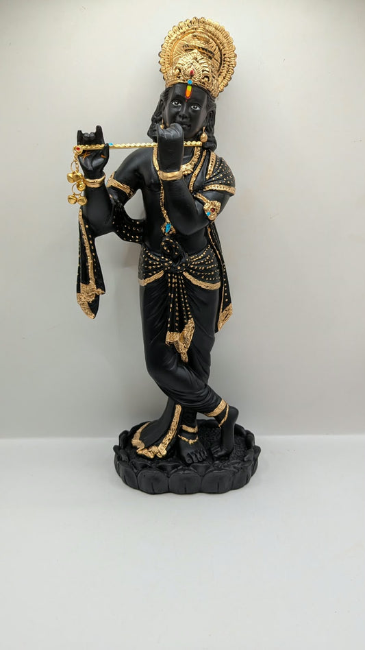Tall black and gold Krishna statue on lotus base, front view