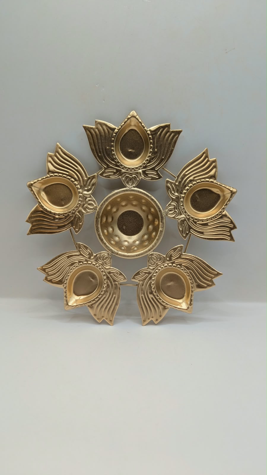 Gold metal urli bowl with 5 petal diyas, front view