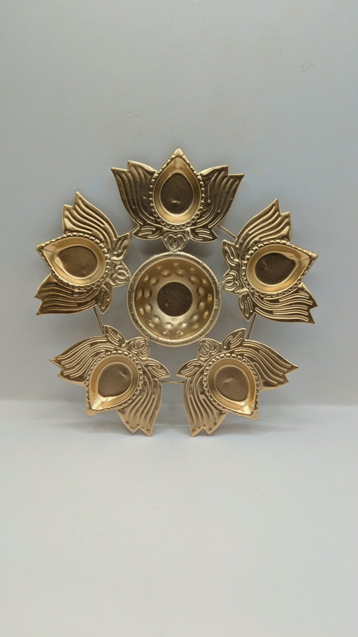 Gold metal urli bowl with 5 petal diyas, front view