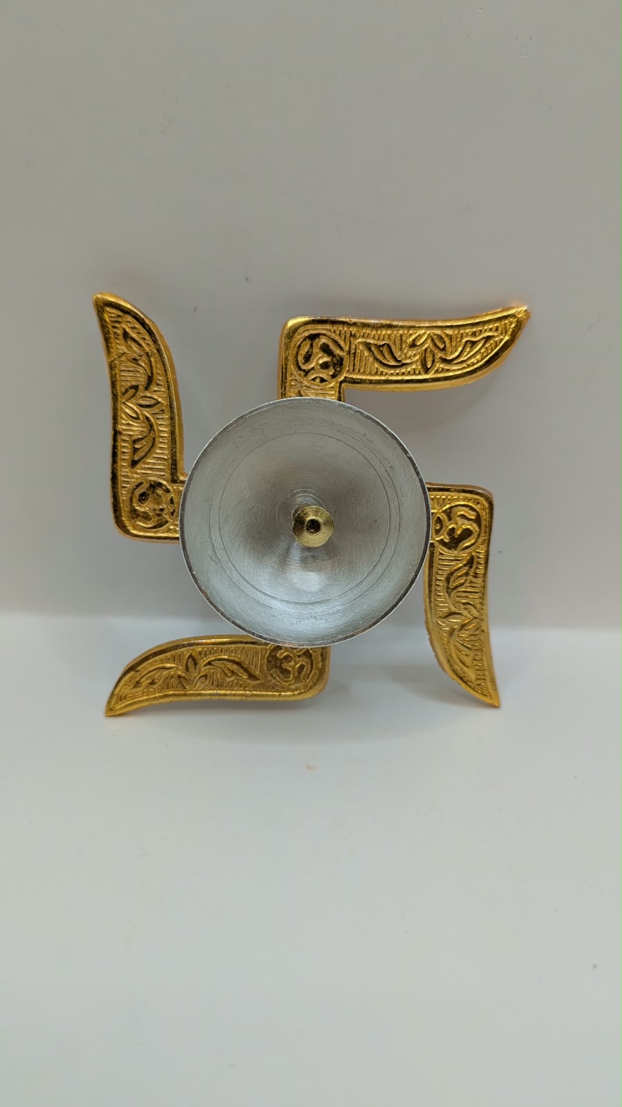 Gold and silver swastik diya, top view