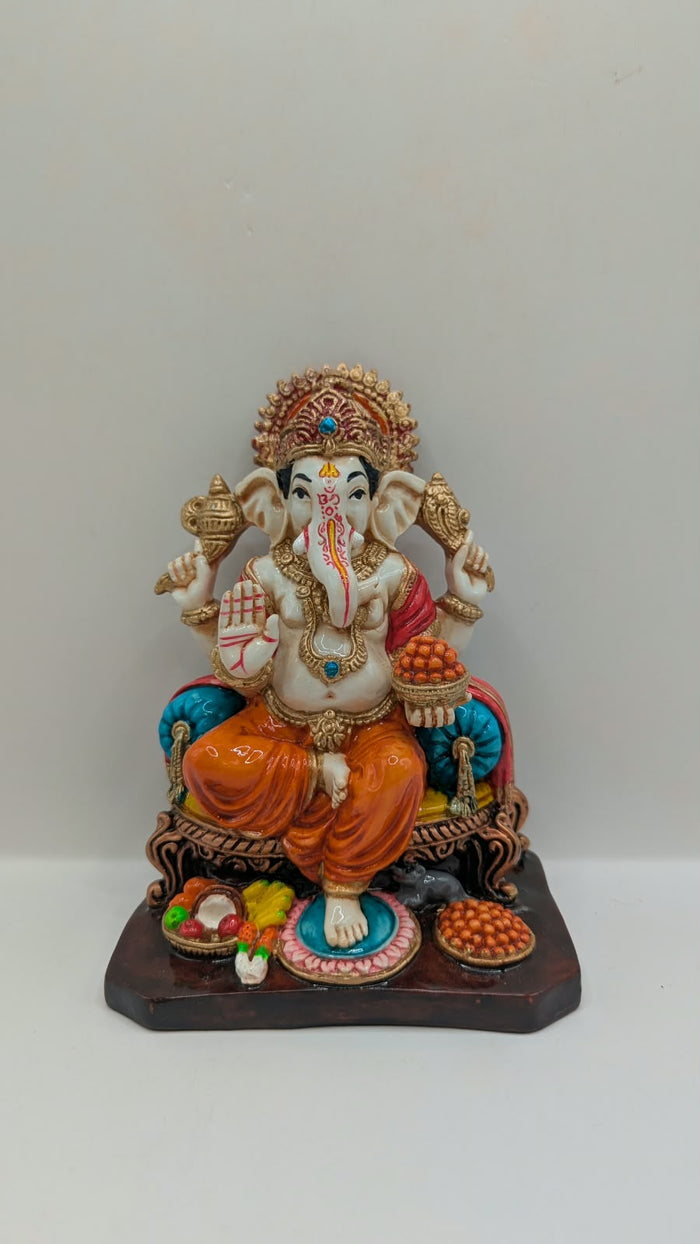 Orange and gold Ganesh statue on throne, front view