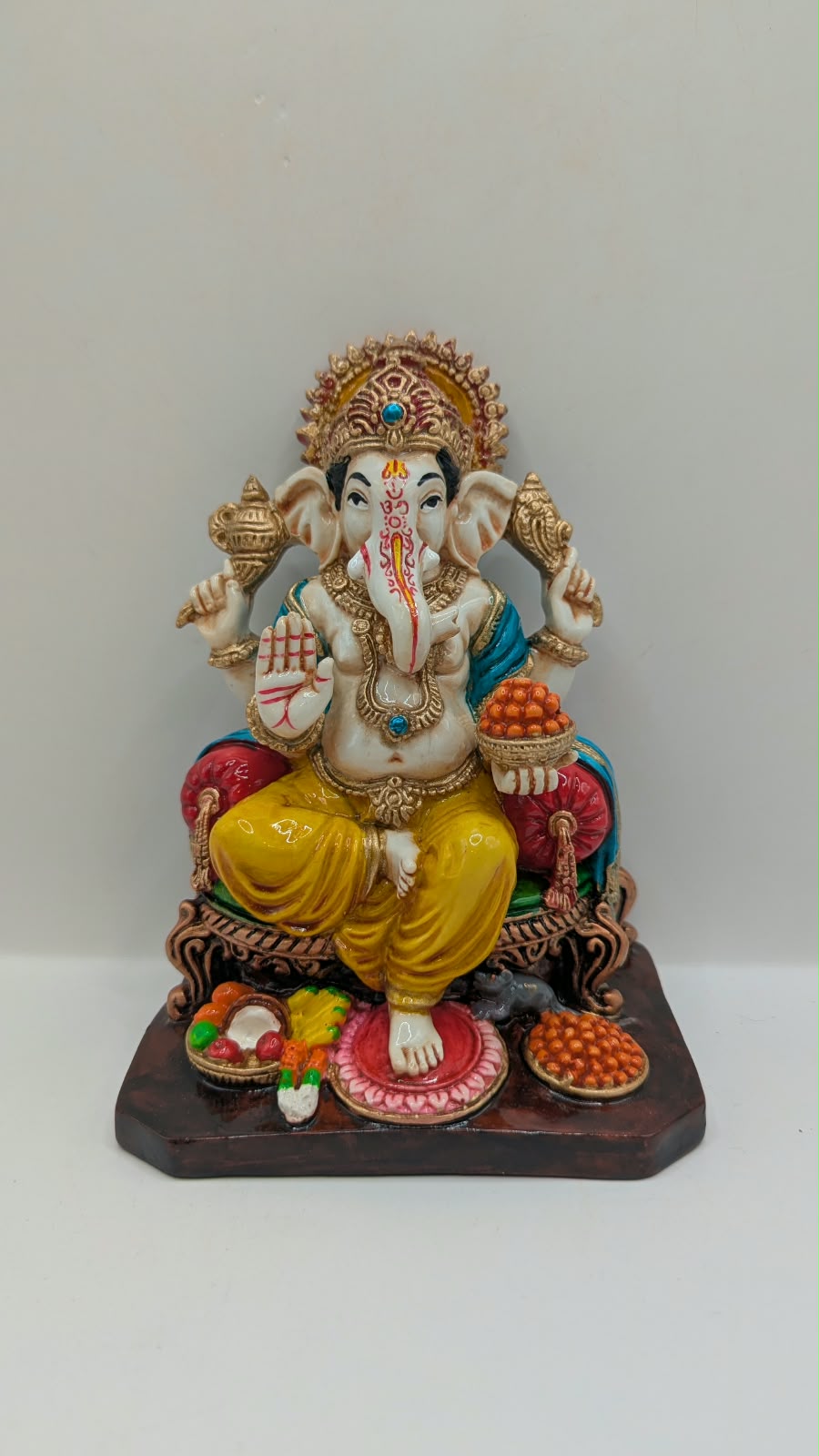 Yellow and gold Ganesh statue on throne, front view