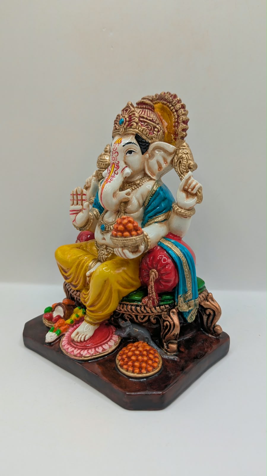 Yellow and gold Ganesh statue on throne, other side view