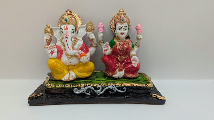 Ganesh and Laxmi statue on green mat, front view