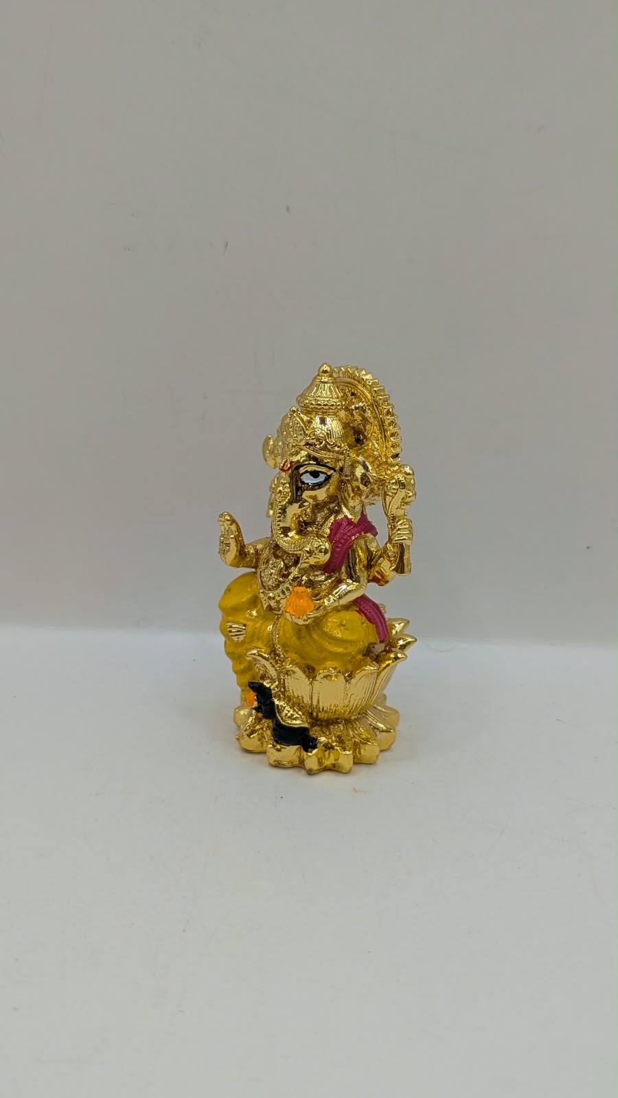 Gold Ganesh murti on lotus, other side view