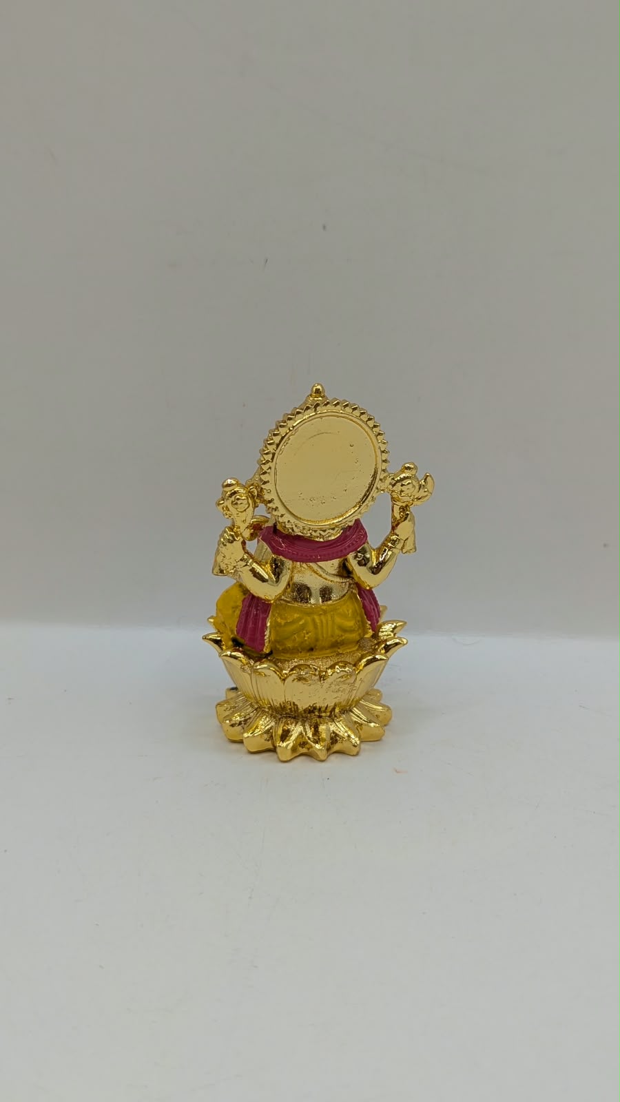 Gold Ganesh murti on lotus, back view