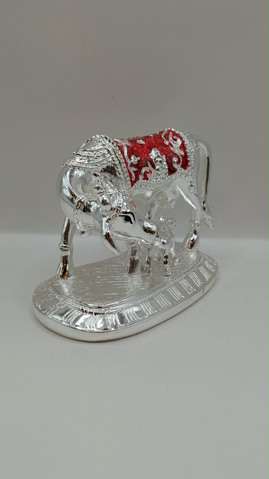 Silver Kamdhenu cow and calf statue, side view
