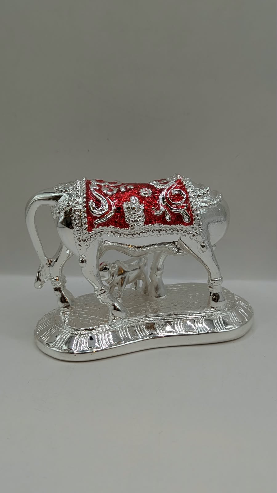 Silver Kamdhenu cow and calf statue, back view