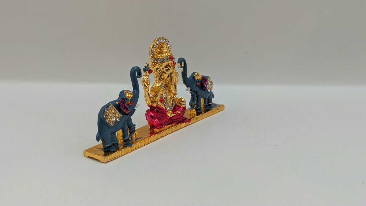 Gold Ganesh murti with two elephants, side view