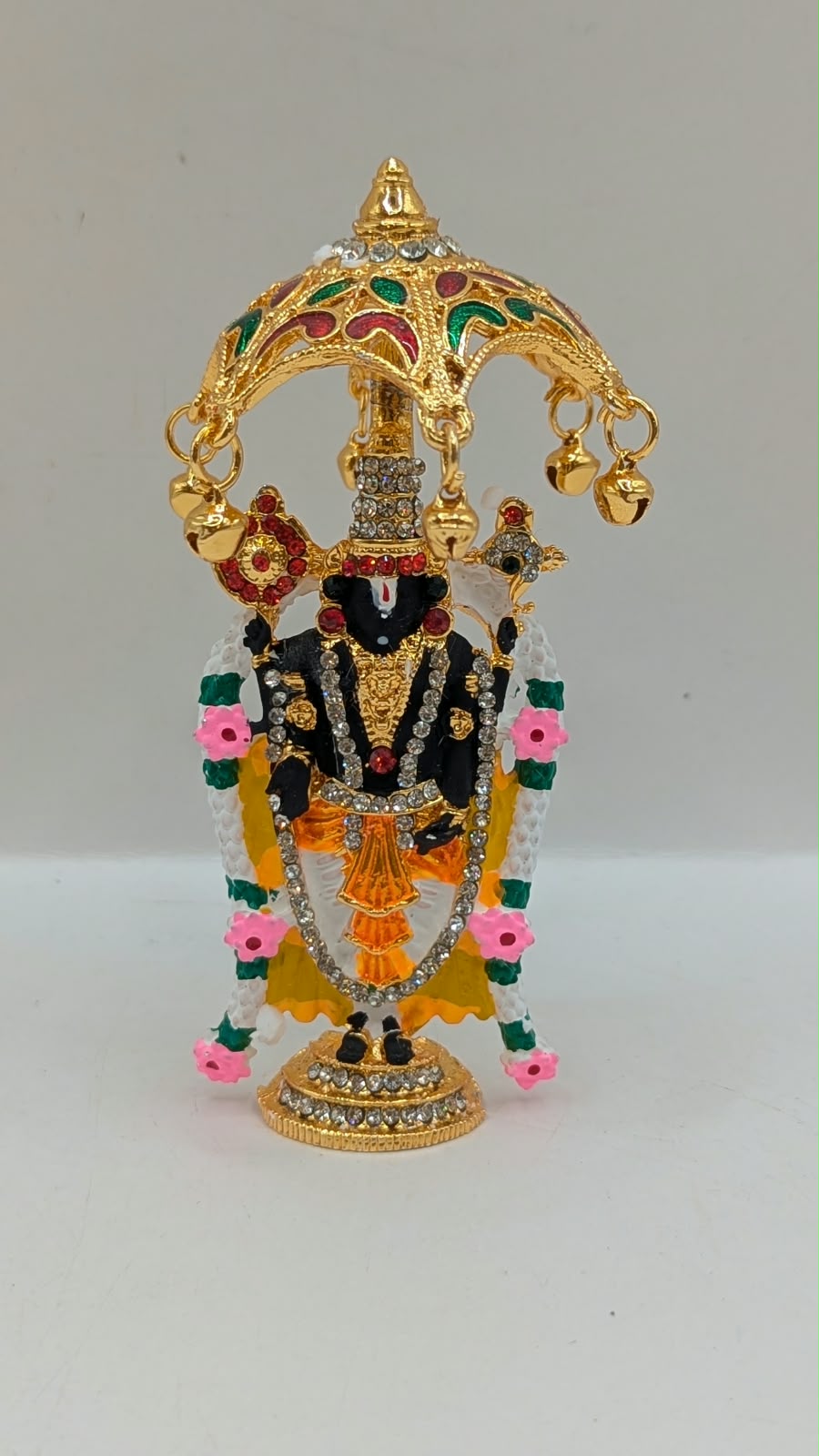 Gold Tirupati Balaji murti under umbrella, front view