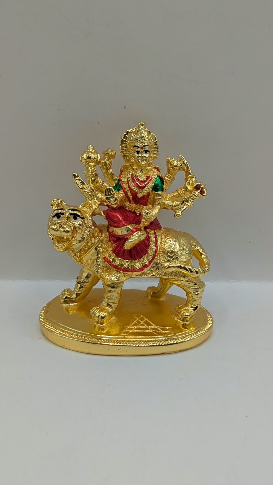 Gold Durga Mata murti with red saree on lion, front view