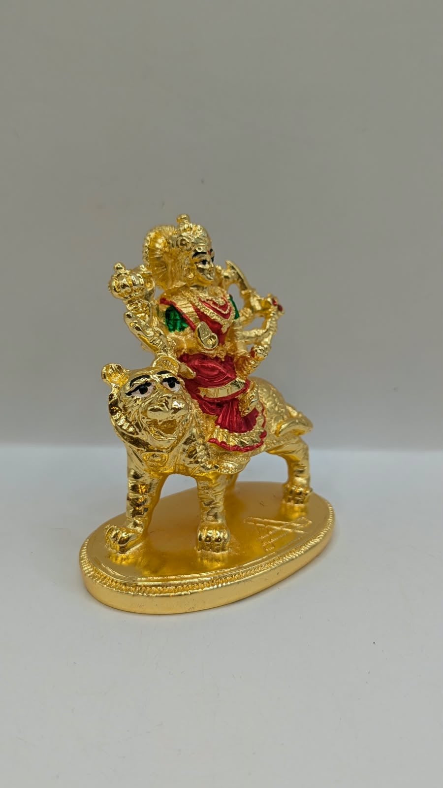 Gold Durga Mata murti with red saree on lion, side view
