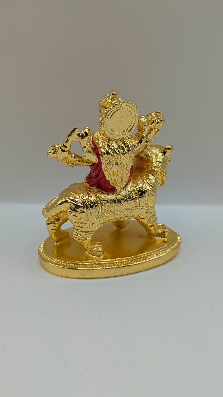 Gold Durga Mata murti with red saree on lion, back view