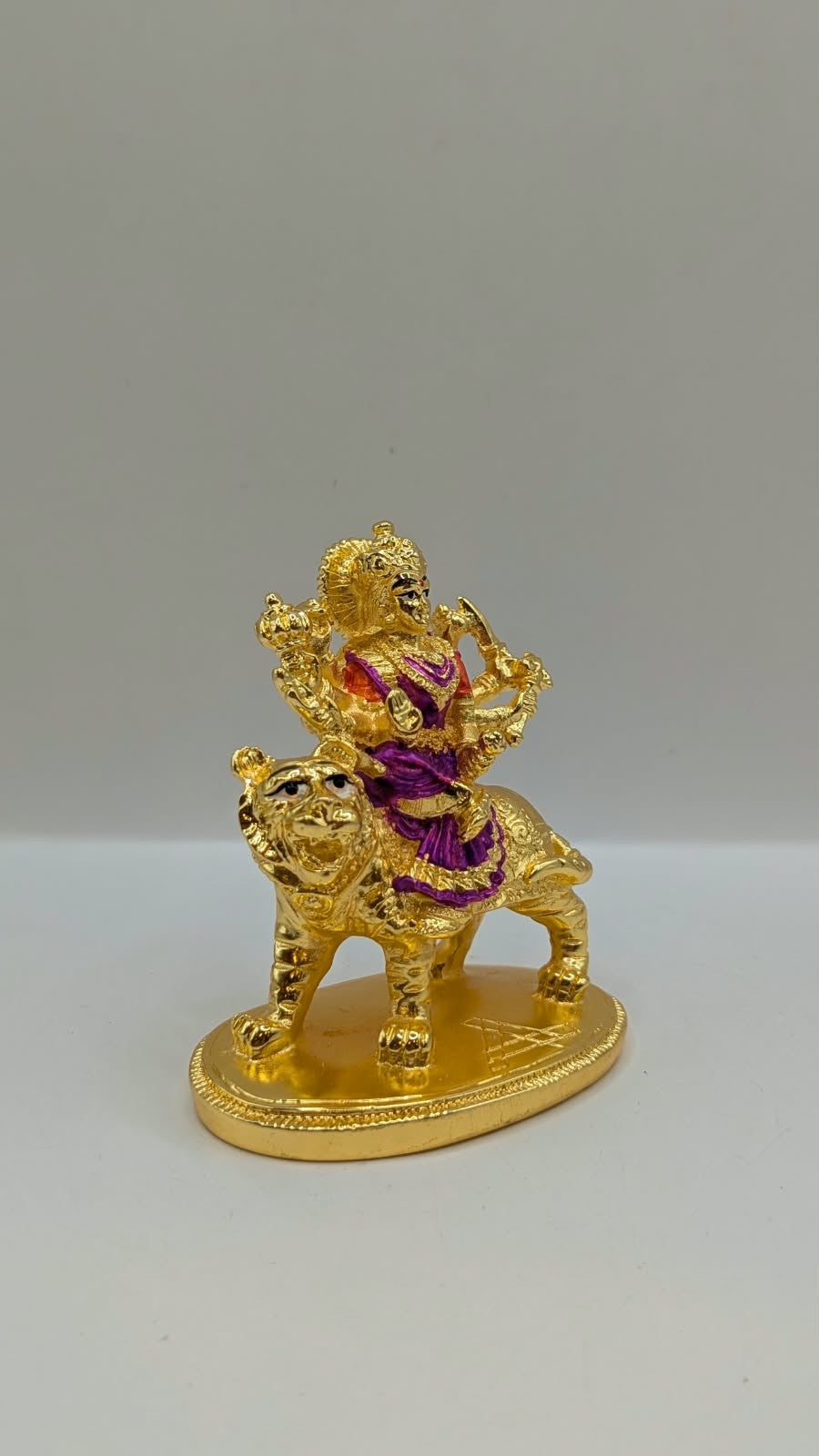 Gold Durga Mata murti with purple saree on lion, side view