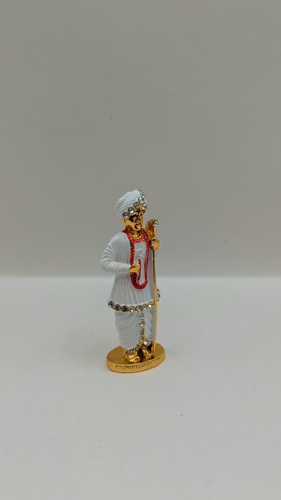 White and gold Jalaram Bapa murti, side view