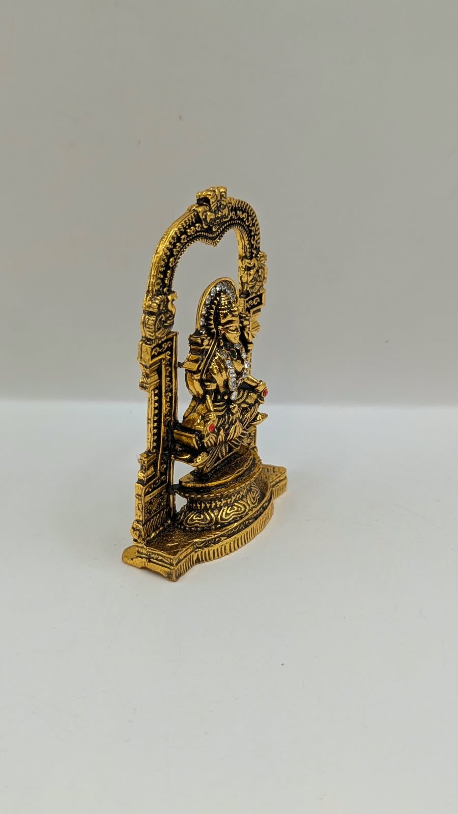 Antique gold Laxmi murti in temple arch, side view