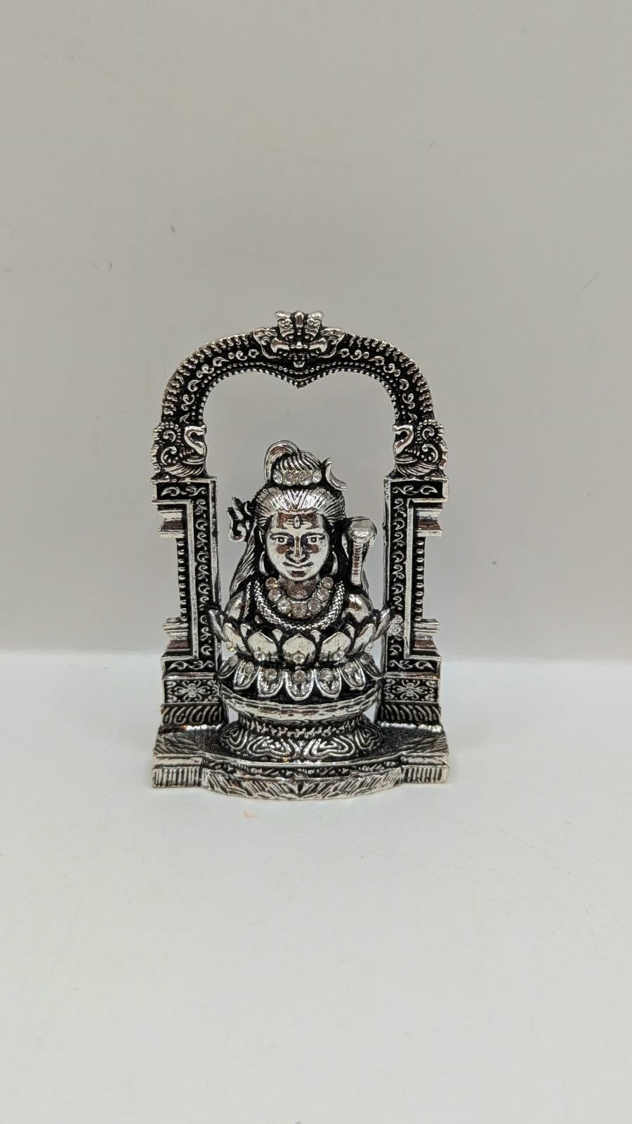Silver Shiva murti in temple arch on lotus, front view