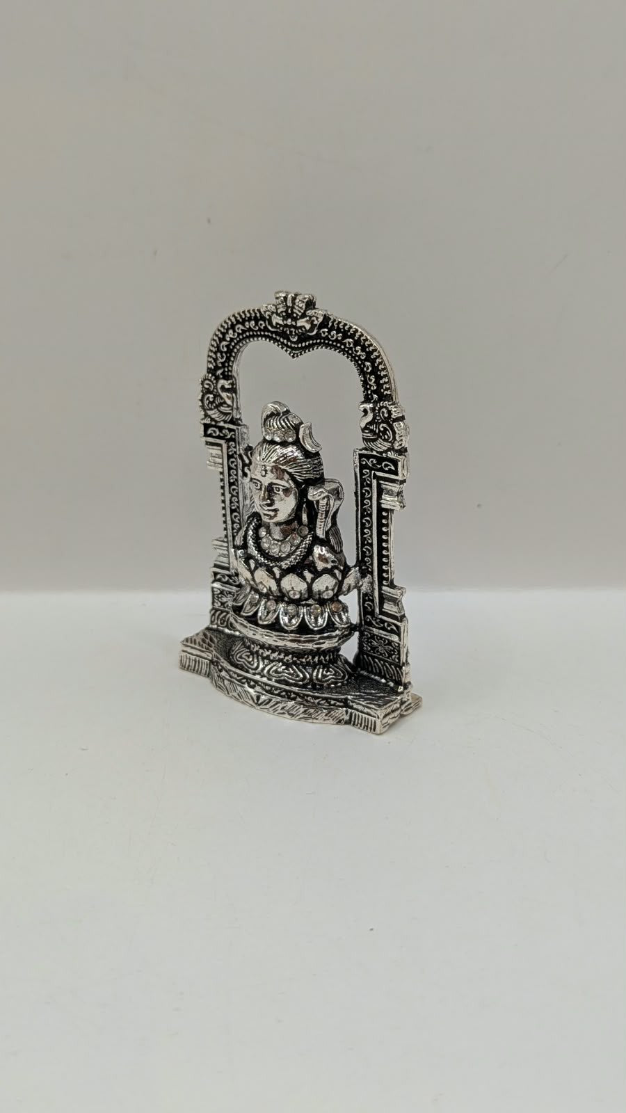 Silver Shiva murti in temple arch on lotus, other side view