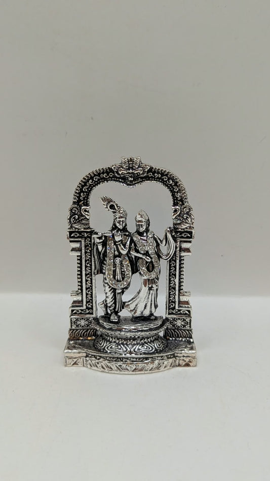 Silver Radha Krishna murti in temple arch, front view