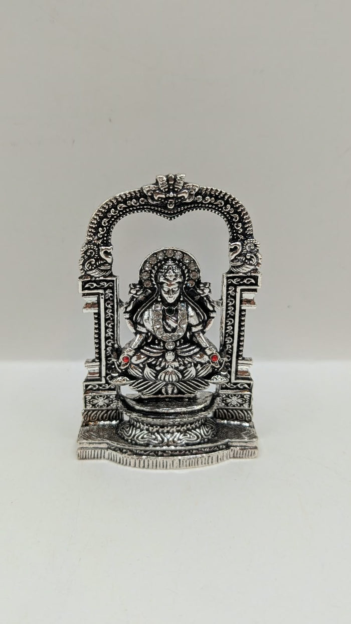 Silver Laxmi murti in temple arch, front view