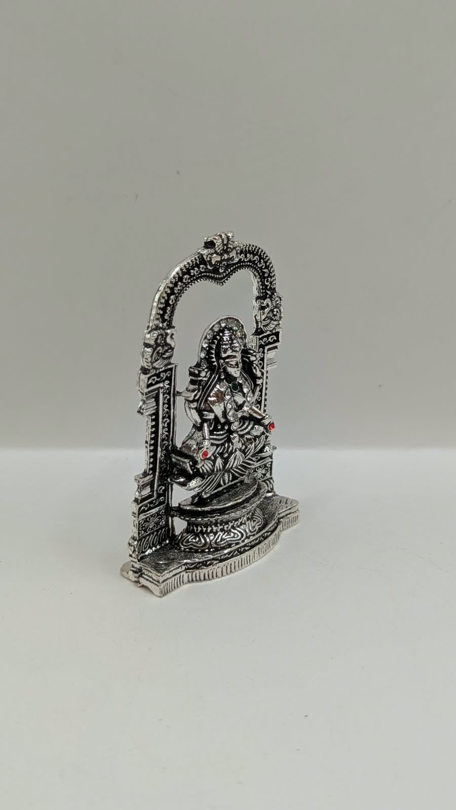 Silver Laxmi murti in temple arch, side view