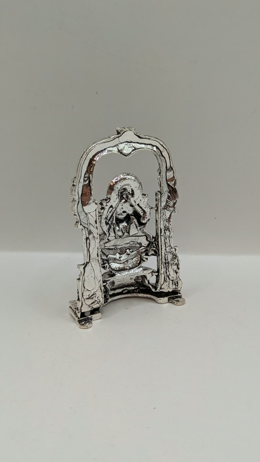 Silver Laxmi murti in temple arch, back view