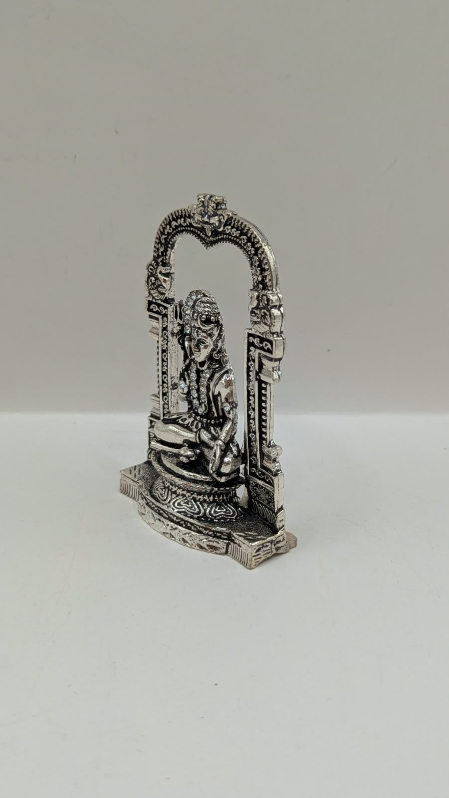 Silver sitting Shiva murti in temple arch, other side view