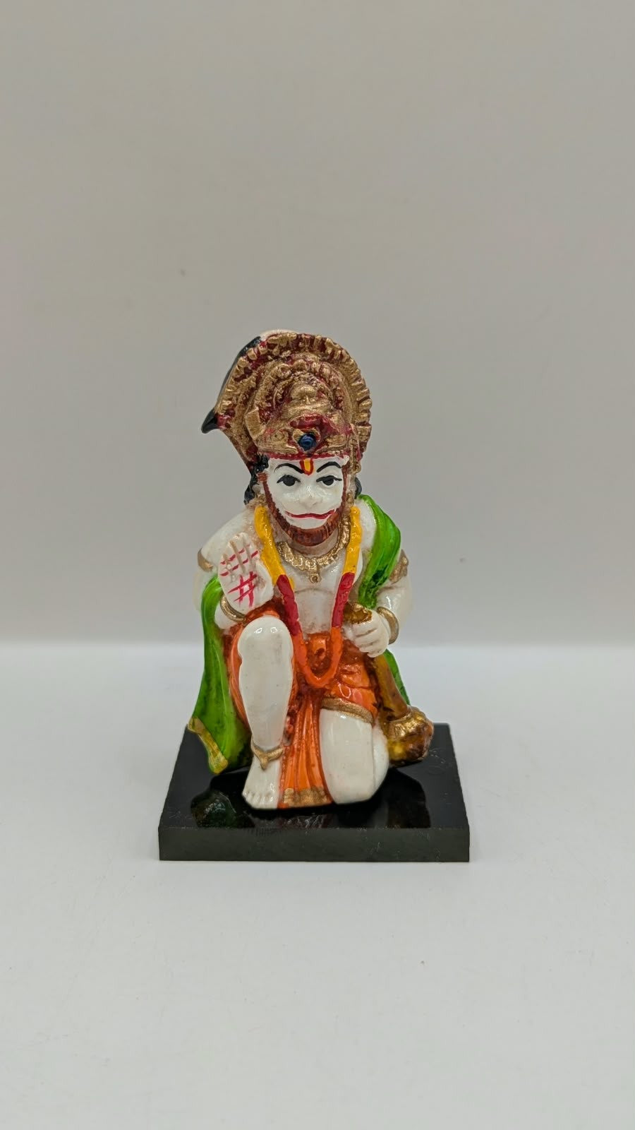 Green and orange kneeling Hanuman resin statue, front view