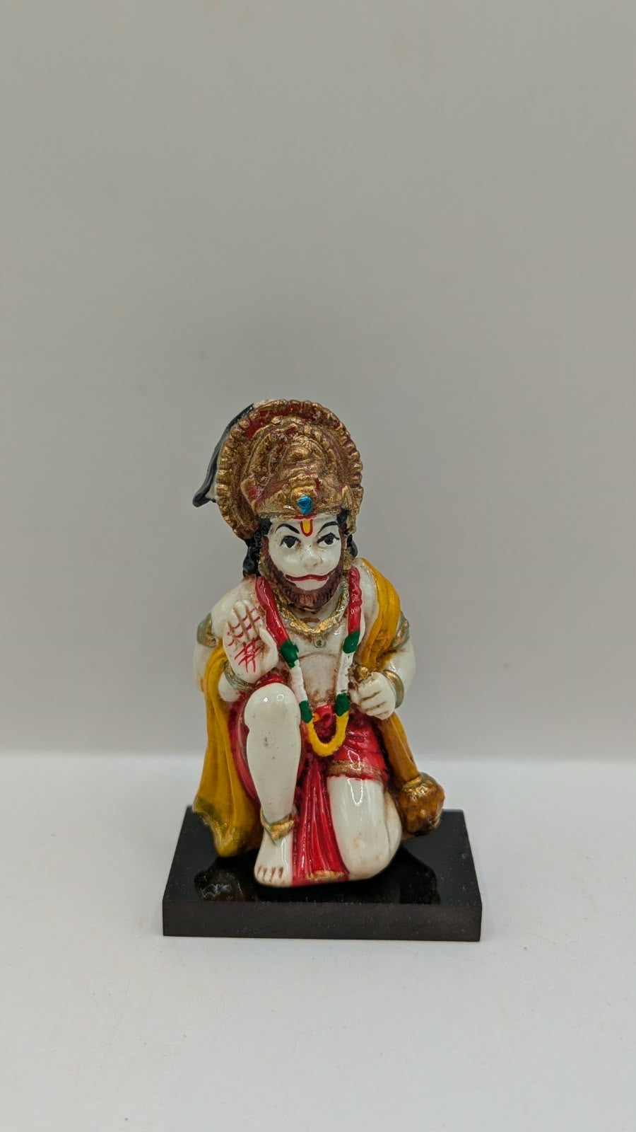Yellow and red kneeling Hanuman resin statue, front view