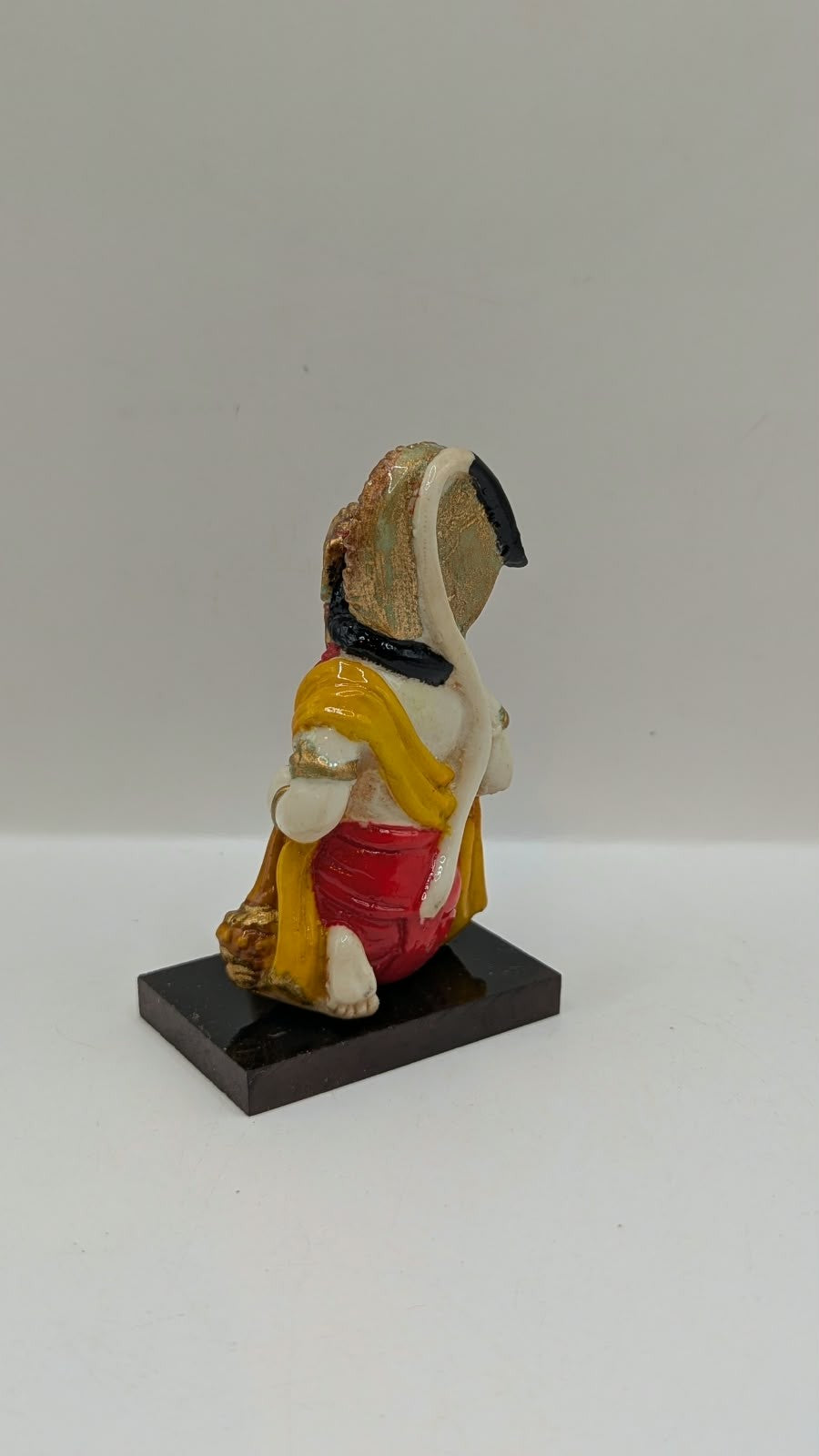 Yellow and red kneeling Hanuman resin statue, back view