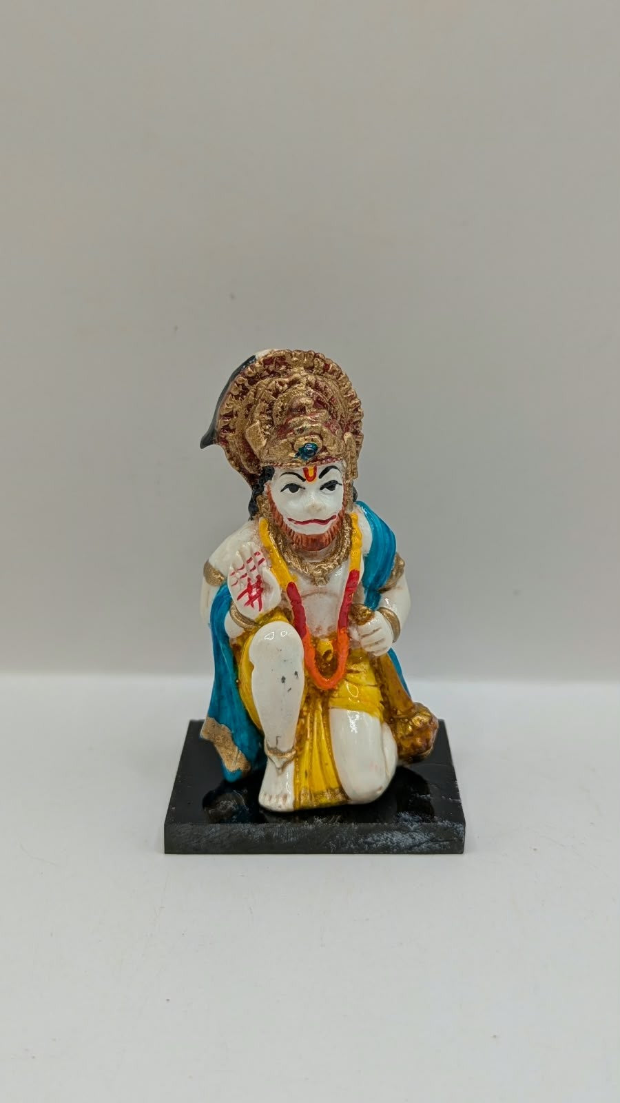 Blue and yellow kneeling Hanuman resin statue, front view