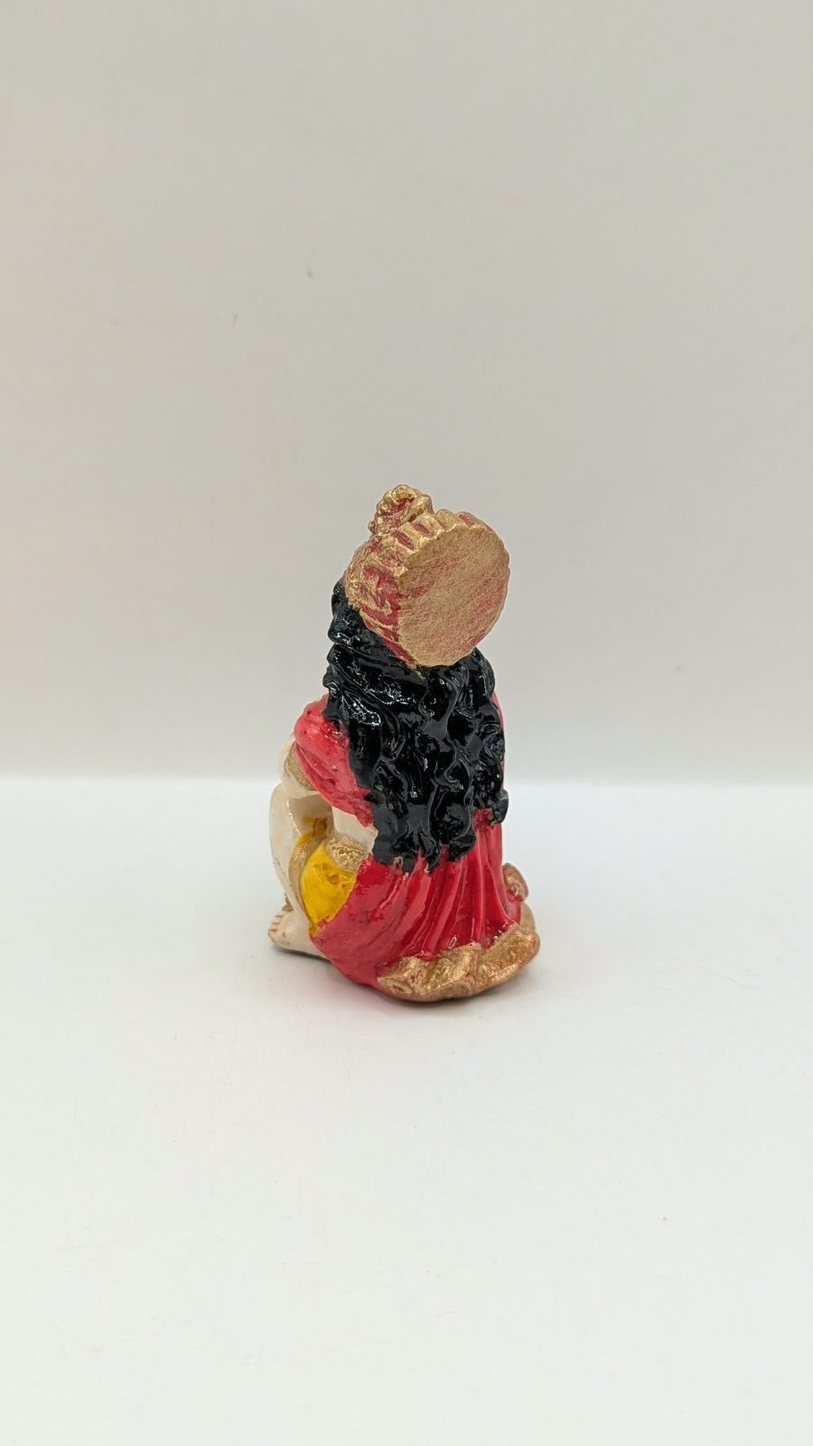 Red and yellow praying Hanuman resin statue, back view