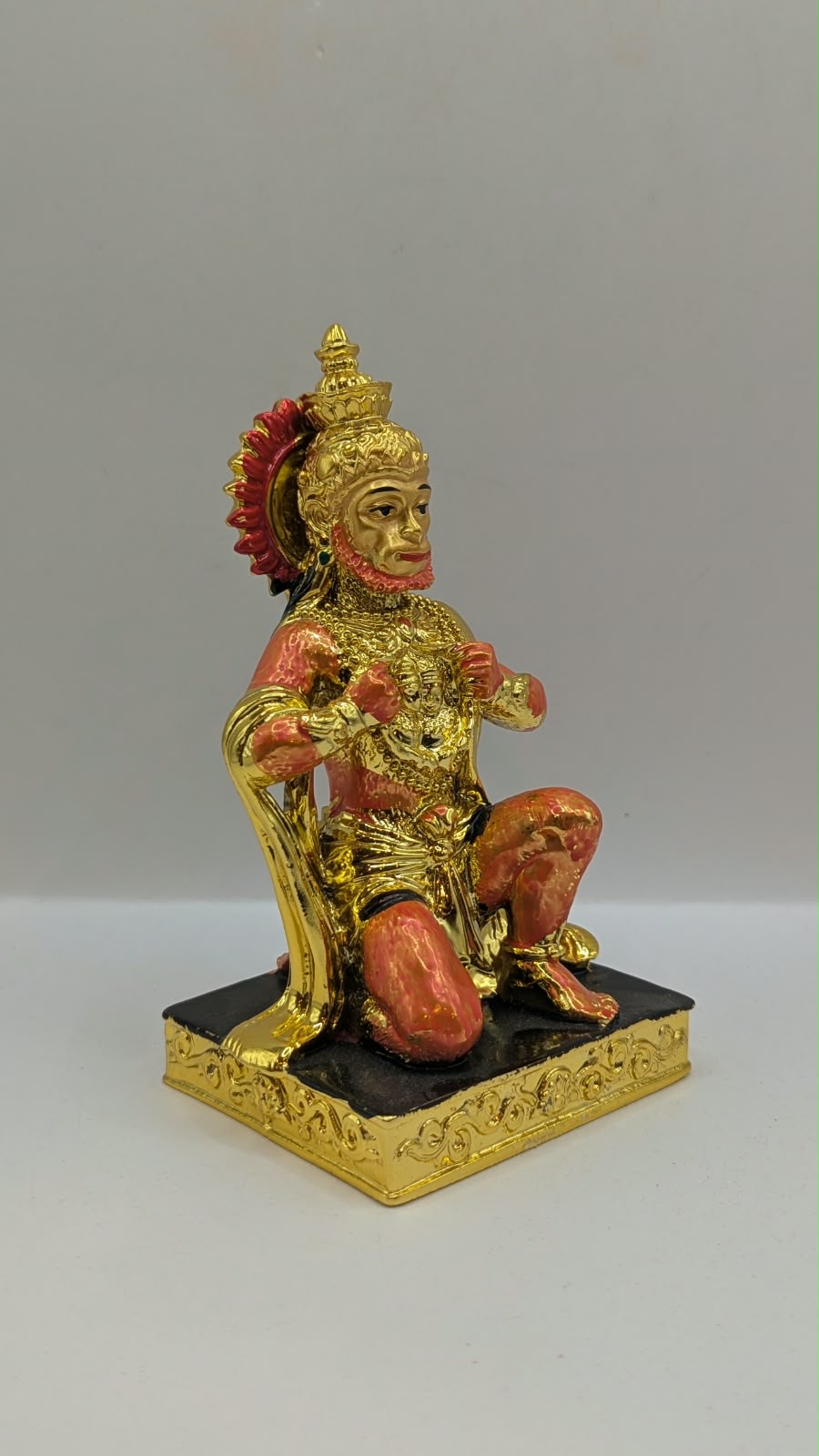 Gold and orange kneeling Hanuman resin statue, side view