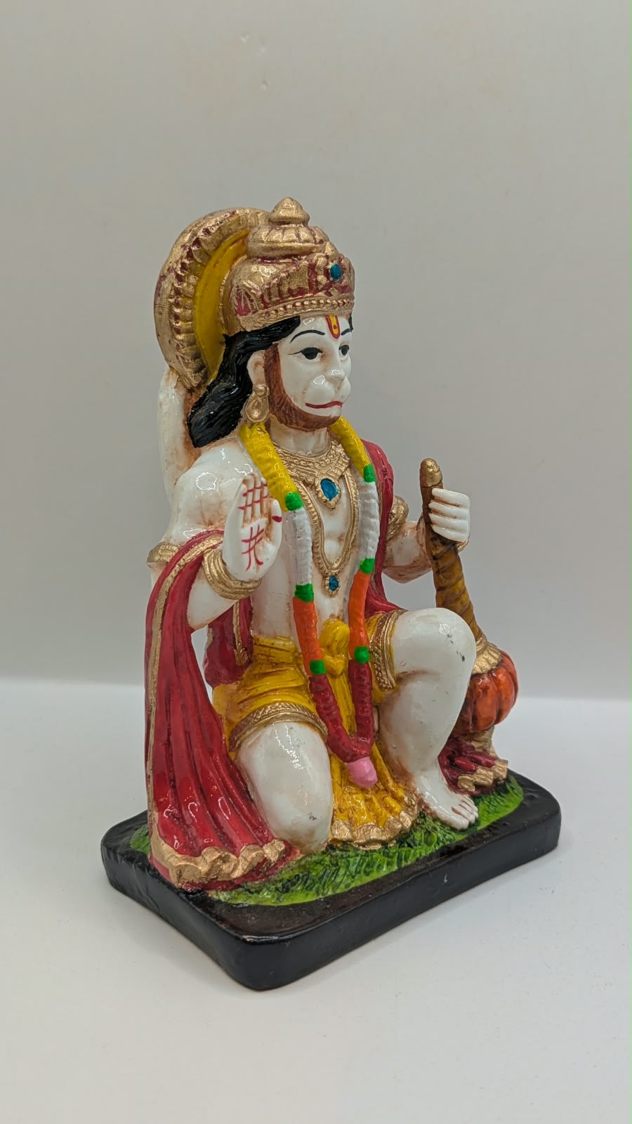White and red kneeling Hanuman resin statue, side view