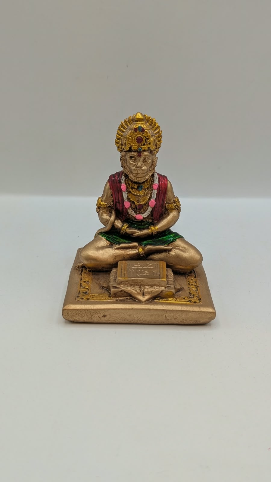 Gold and maroon Hanuman reading Ramayan resin statue, front view