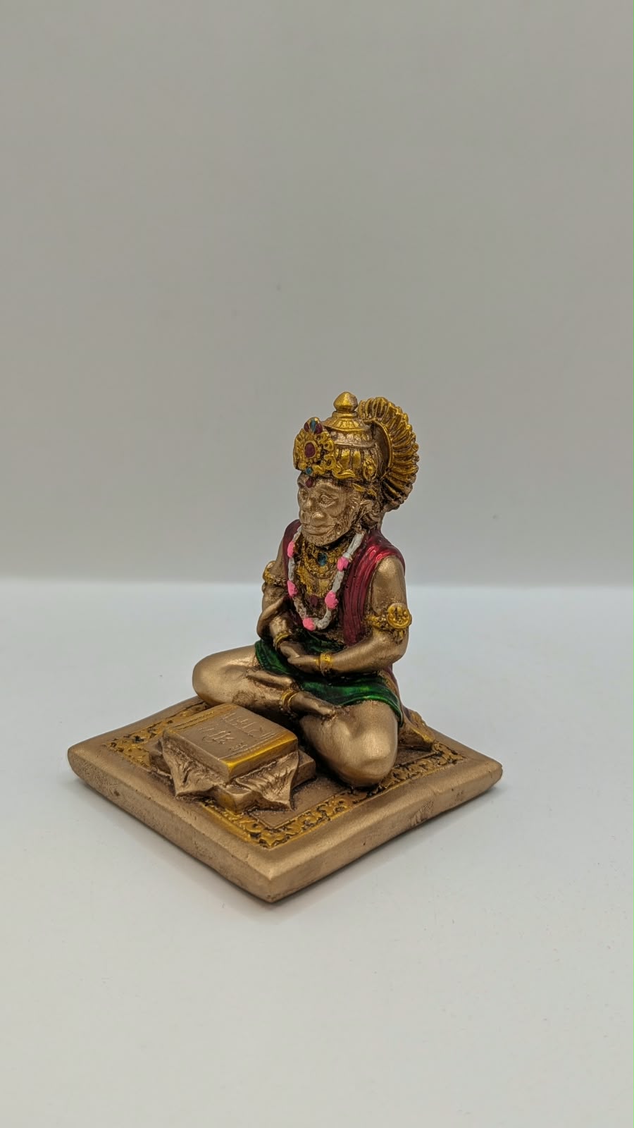 Gold and maroon Hanuman reading Ramayan resin statue, other side view
