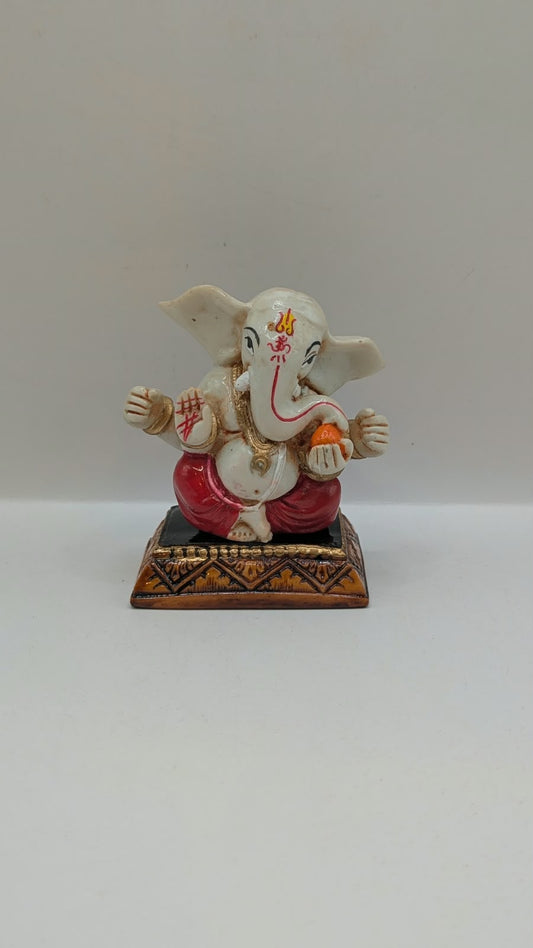 White and red Ganesh resin statue, front view