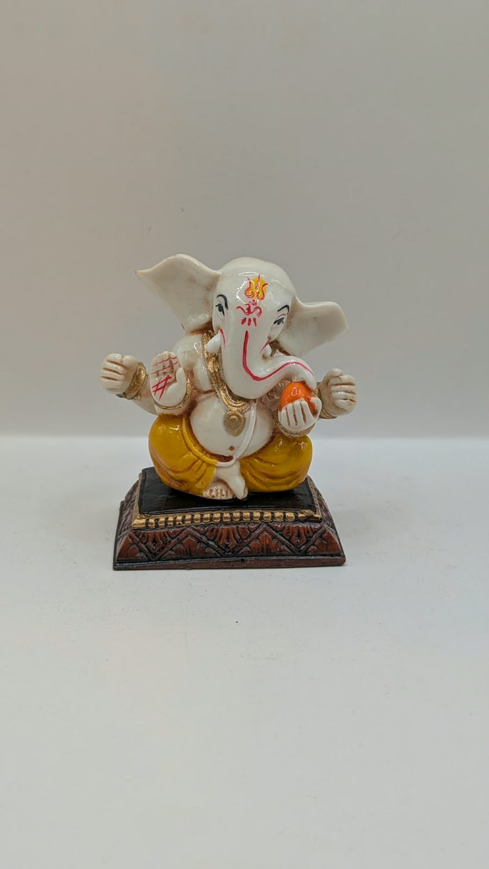 White and yellow Ganesh resin statue, front view