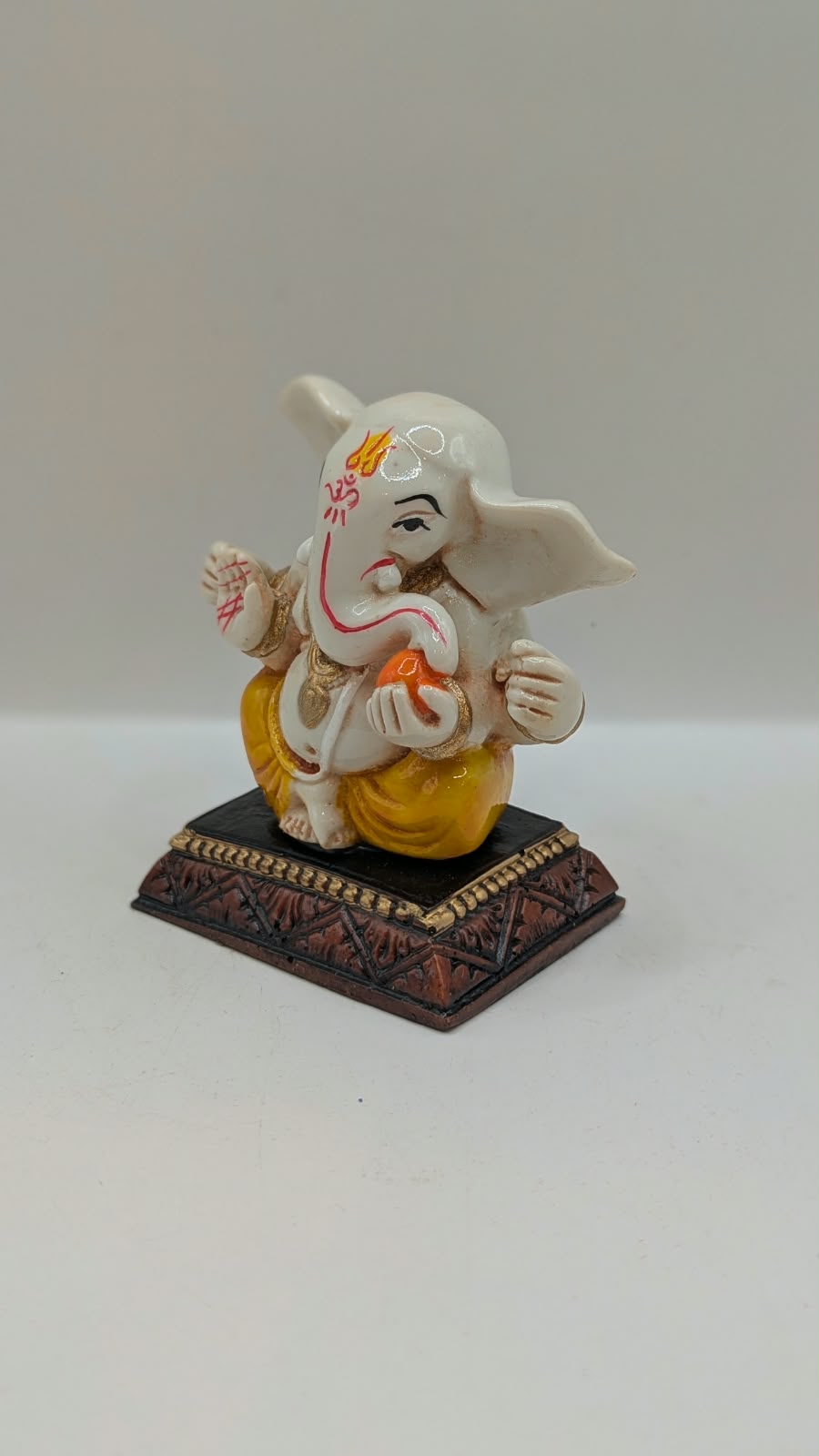 White and yellow Ganesh resin statue, other side view