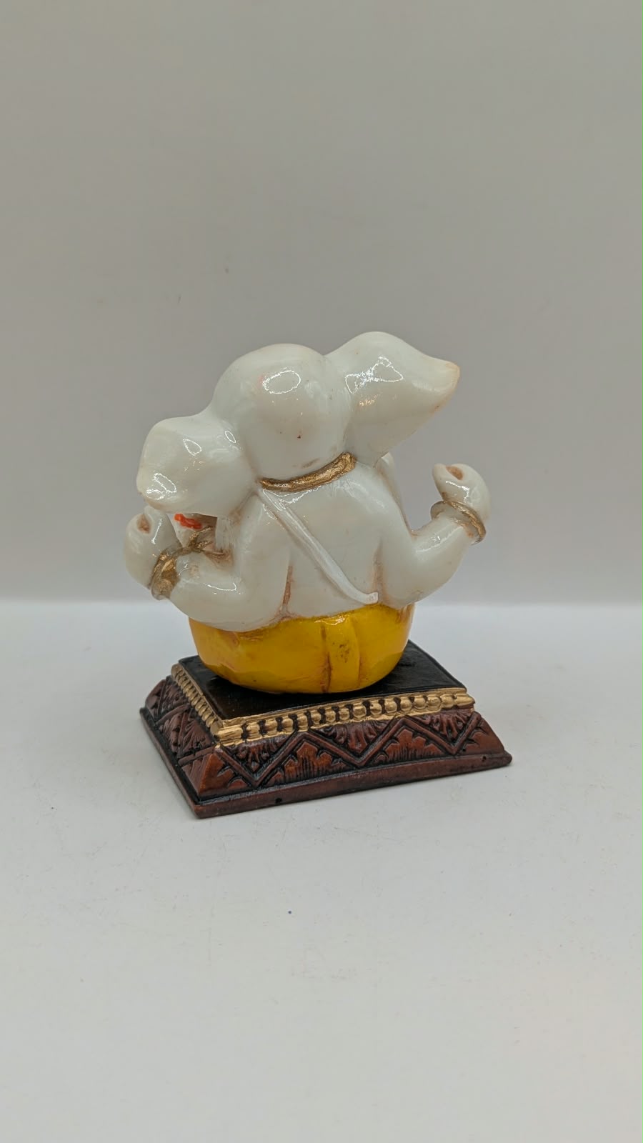 White and yellow Ganesh resin statue, back view