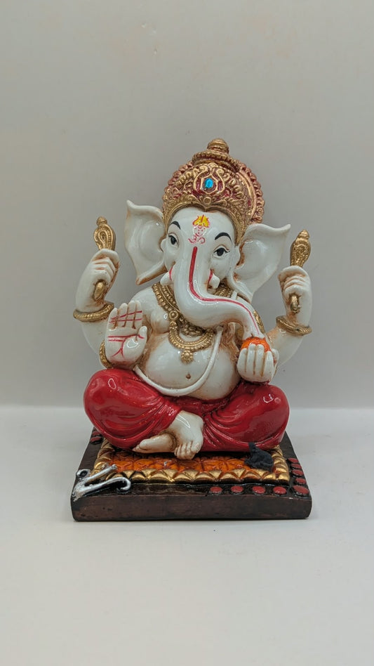White and red Ganesh resin statue with copper crown, front view