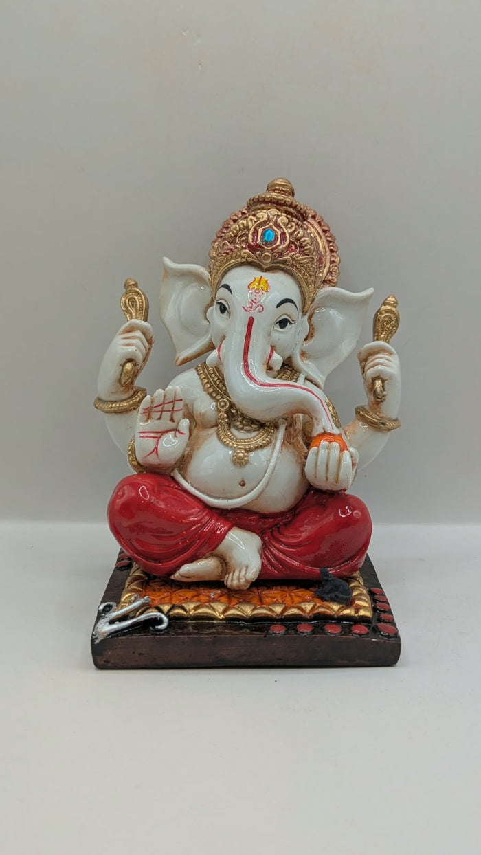 White and red Ganesh resin statue with copper crown, front view