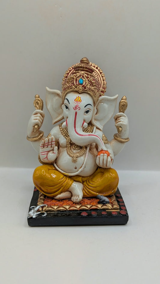 White and yellow Ganesh resin statue with copper crown, front view